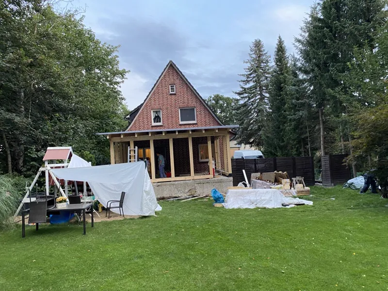 Wohnhaus mit neu gebauter Hauserweiterung: überdachter Anbau auf gemauertem Sockel