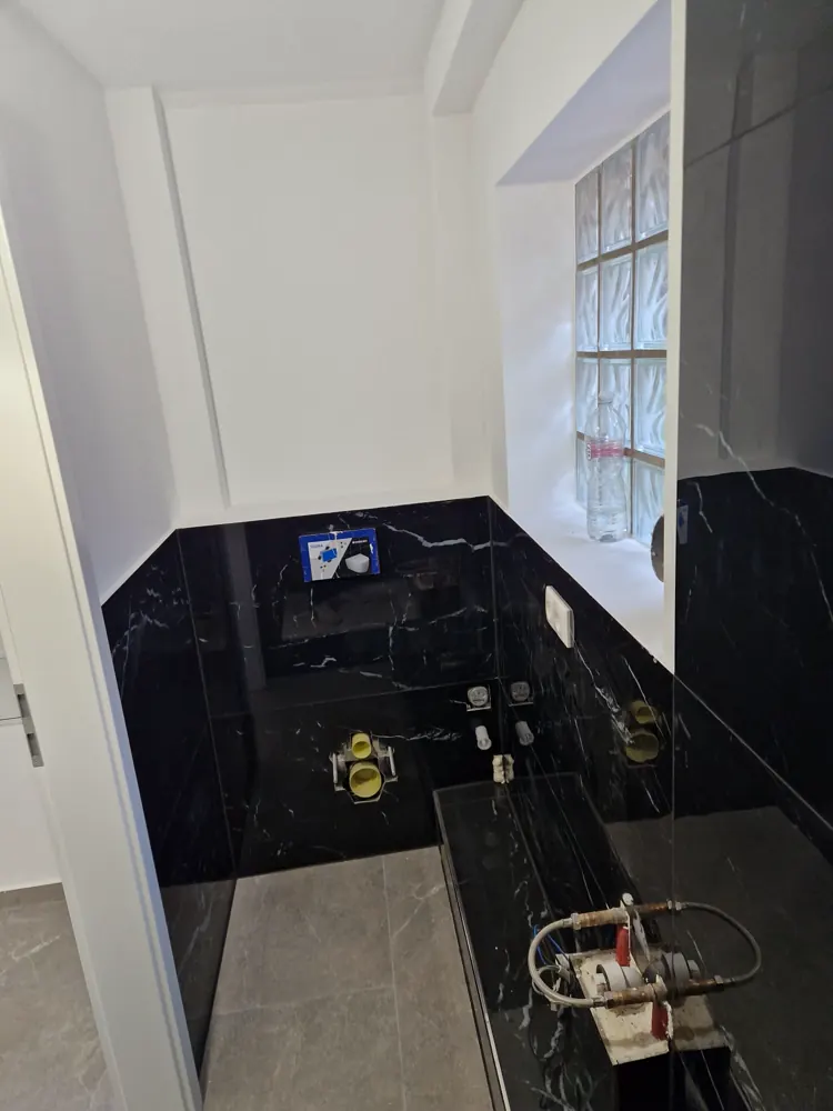 Gäste-WC in schwarzem Marmor mit Glasbausteinfenster und vorbereiteten Anschlüssen
