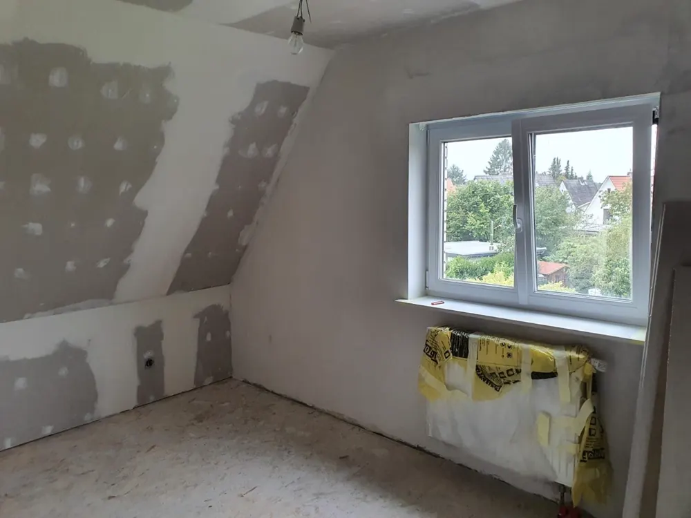 Beplankte und gespachtelte Dachschräge mit neuem Fenster und abgeklebtem Heizkörper