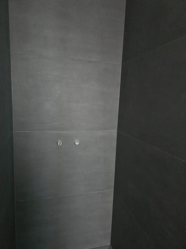 Detail einer großformatig gefliesten Wandfläche mit schmaler Fuge