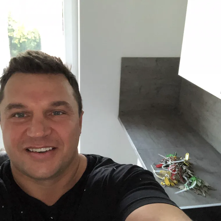 Oleg Prusincov in einem fertigen Raum, daneben die Schlüssel zur Übergabe