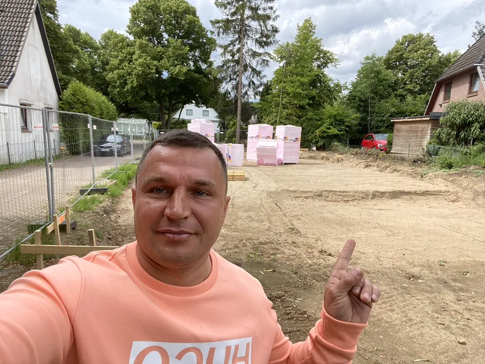Grundstück nach dem Abriss des Altbaus: Bauzaun, abgezogener Sand, Dämmplatten auf Paletten