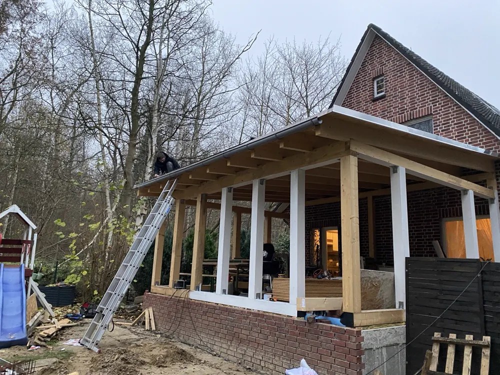 Montage der Dachfläche und der Regenrinne an der überdachten Terrasse
