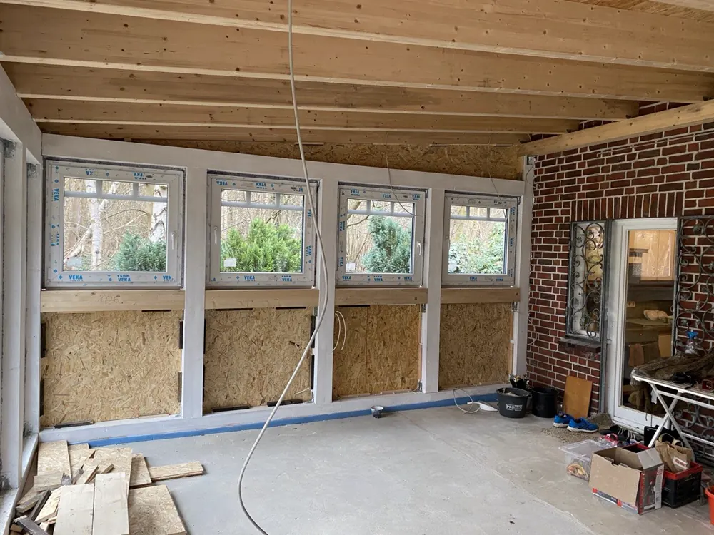Innenansicht der verglasten Veranda mit Fensterband, Holzdecke und Klinkerwand