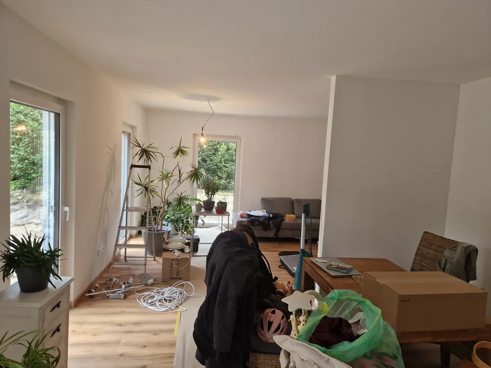 Fertig sanierter heller Wohnraum mit neuem Dielenboden und bodentiefer Fensterfront